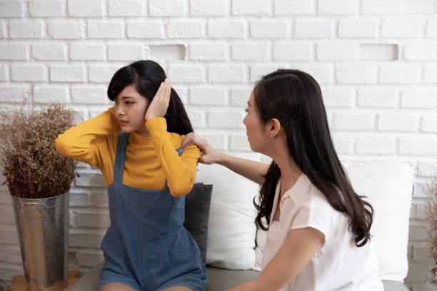 Asian family Teenage daughte closed his ears with his hands while her mother yells at her at home. Family crisis, conflict and relationships problems concept Asian family Teenage daughte closed his ears with his hands while her mother yells at her at home. Family crisis, conflict and relationships problems concept asian mother talking with daughter stock pictures, royalty-free photos & images