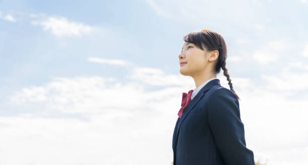 空を見上げるアジアの女子高校生。 - 制服 ストックフォトと画像