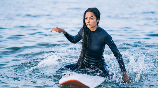 Asian female surfer in sea