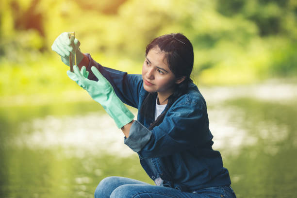 Asian Female working checking controlling the quality of water with glass tube. stock photo