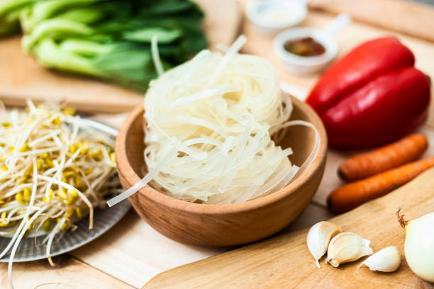 Asian food, dried rice noodles with ingredients on table, close up stock photo