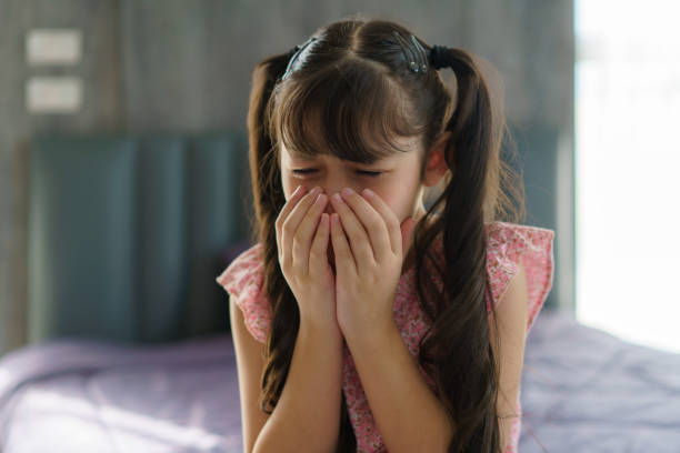 Asian girl child sad, offended, crying on the bed in the bedroom, concept of children's emotions, sadness and frustration stock photo