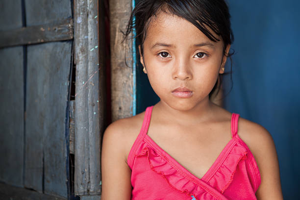 Asian girl living in poverty Portrait of a young girl from poverty-stricken area in Manila, the Philippines. philippine girl stock pictures, royalty-free photos & images