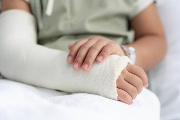 лежа на кровати больно со сломанной рукой назад от операции. - child cast h...