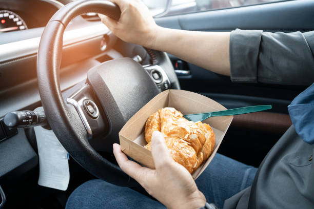 Asian lady holding bread bakery food in car, dangerous and risk an accident. Asian lady holding bread bakery food in car, dangerous and risk an accident. distracted stock pictures, royalty-free photos & images