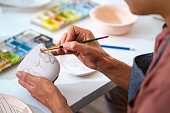 istock Asian LGBTQ guy painting self-made pottery at home studio. 1345924486