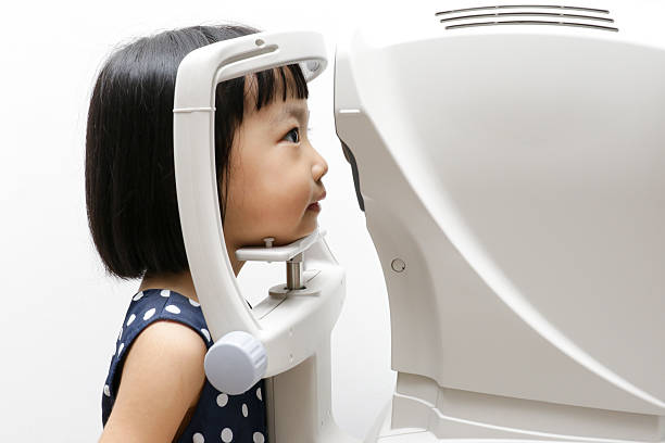 Asian Little Chinese Girl Doing Eyes Examination Through Auto re stock photo