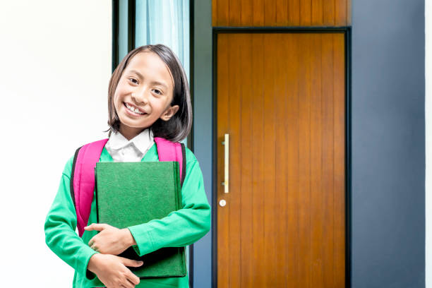 Asian little girl with book and backpack going to the school Asian little girl with book and backpack going to the school. Back to School concept philippines girl stock pictures, royalty-free photos & images