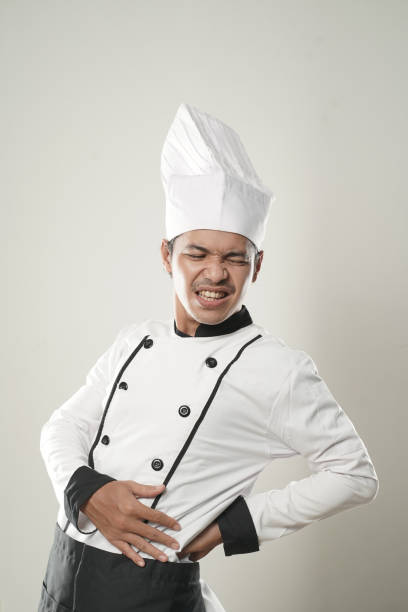 uomo asiatico chef sensazione di backpain su sfondo bianco - chef backache foto e immagini stock