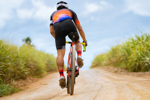 Asian man cycling on gravel road. stock photo