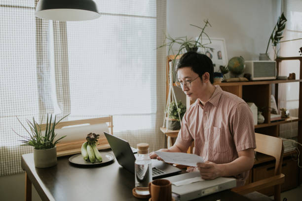 Asian man hold electricity bill for planing his expenses. stock photo