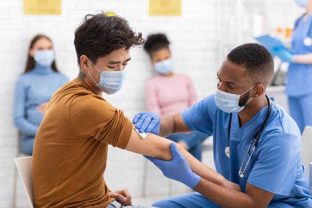 azjatycki mężczyzna otrzymujący zastrzyk szczepionki coronavirus podczas wizyty w szpitalu - covid vaccine zdjęcia i obrazy z banku zdjęć