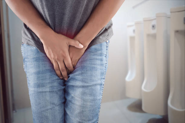 Asian man wants to pee and is holding his bladder. stock photo