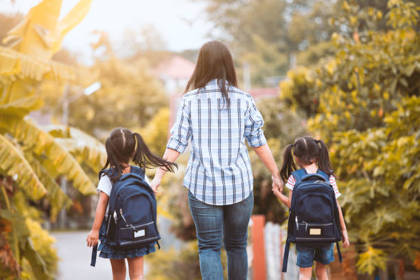 Asian mother and daughter pupil girl with backpack holding hand and going to school Back to school. Asian mother and daughter pupil girl with backpack holding hand and going to school together in vintage color tone asian kid stock pictures, royalty-free photos & images