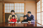 書道を実践するアジアの多世代家族