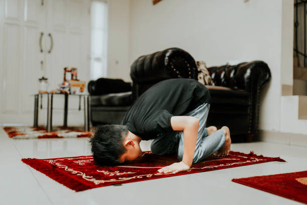 asiatico ragazzo musulmano sta pregando in casa - salah foto e immagini stock