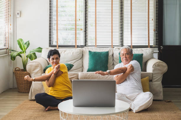 ejercicio asiático de entrenamiento para personas mayores y hacer yoga en casa - actividades y técnicas de relajación fotografías e imágenes de stock