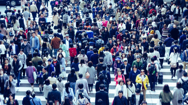 アジアの人々は横断歩道を渡っています - 日本　都市 ストックフォトと画像