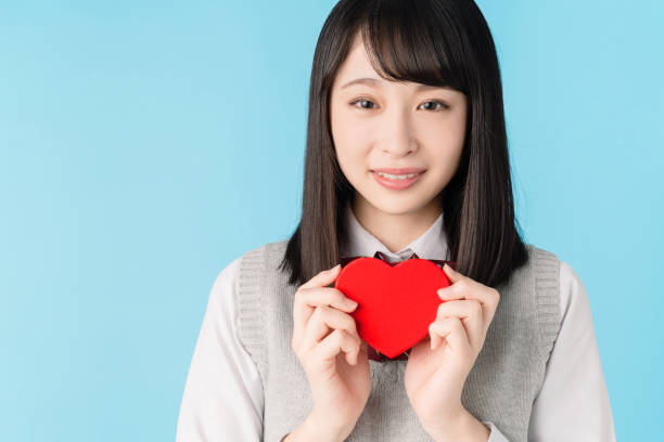 Asian school girl holding a heart shape box. Asian school girl holding a heart shape box. shy japanese woman stock pictures, royalty-free photos & images