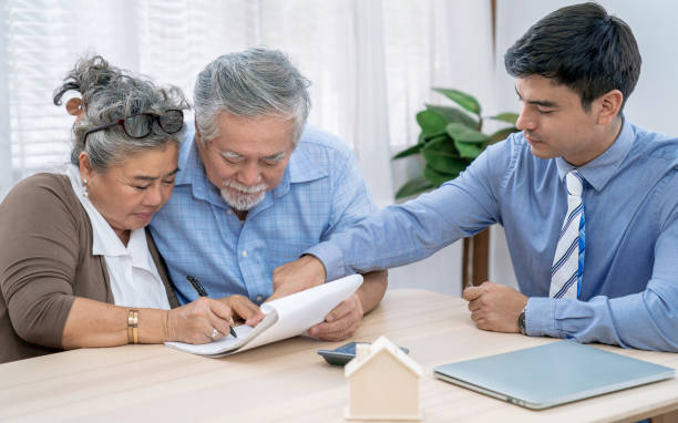 Asian senior couple making sign contract to buy new house. stock photo