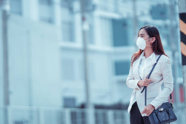 亞洲婦女要上班，她戴著n95口罩。防止pm2.5灰塵和煙霧 - n95 mask 個照片及圖片檔