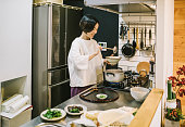 キッチンで調理アジアの女性