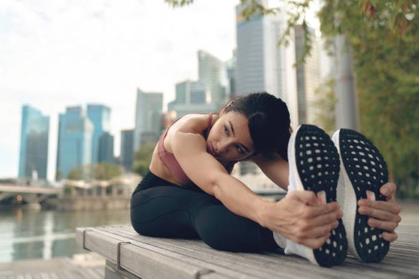 Asian woman doing stretching before proper work out stock photo