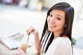 アジア女性のカフェでコーヒーを飲みながら、