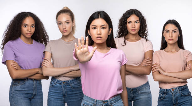 Asian Woman Gesturing Stop Protecting Group Of Ladies, Studio Shot Determined Asian Woman Gesturing Stop Protecting Group Of Diverse Ladies Standing Together Over White Background. Female Group Showing Forbidding Gestures Stopping Something. Panorama, Studio Shot me too social movement stock pictures, royalty-free photos & images