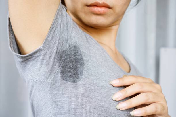 Asian Woman having problem sweat armpits because of hot weather stock photo