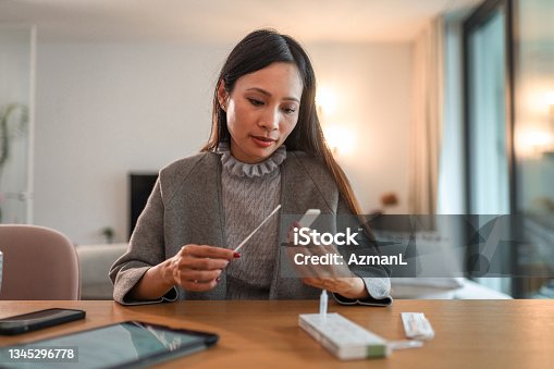 istock Asian Woman Holding Covid Rapid Test And Waiting For Results 1345296778