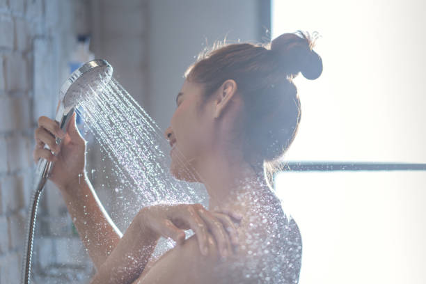 Asian woman is taking a shower and rubbing her shoulders stock photo