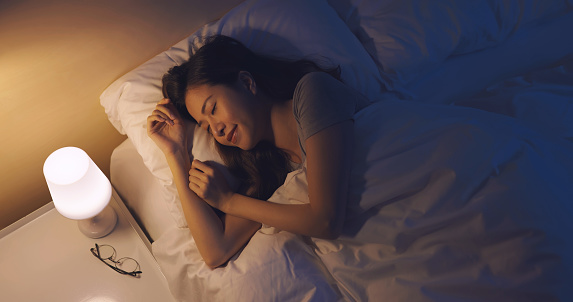 Asian woman sleep well on the bed at night
