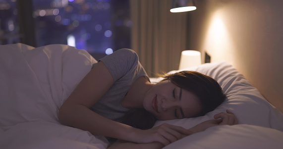 sideview of asian woman sleep well on the bed at night