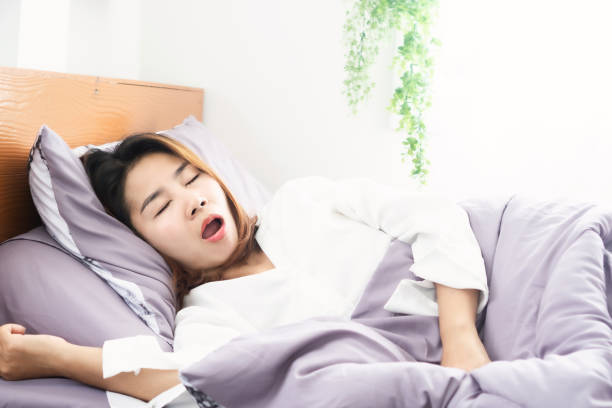 asiatisk kvinna snarkning och öppen mun medan du sover i sängen - nap middle age woman bildbanksfoton och bilder