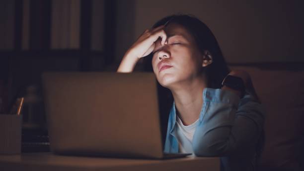 아시아 여자 학생 또는 사업가 는 늦은 밤에 일합니다. 노트북이나 노트북이있는 어두운 방에서 책상에서 졸린 느낌. 사람들의 개념은 열심히 하고 소진 증후군을 합니다. - 과로 뉴스 사진 이미지