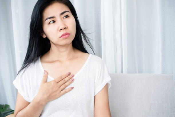 asian woman suffering from heart disease hand holding chest pain - medelålders kvinna bröstsmärtor bildbanksfoton och bilder