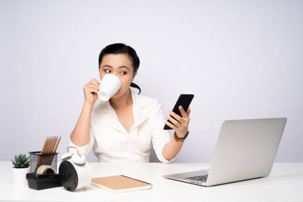 Asian woman take a break after working and using smart phone. stock photo