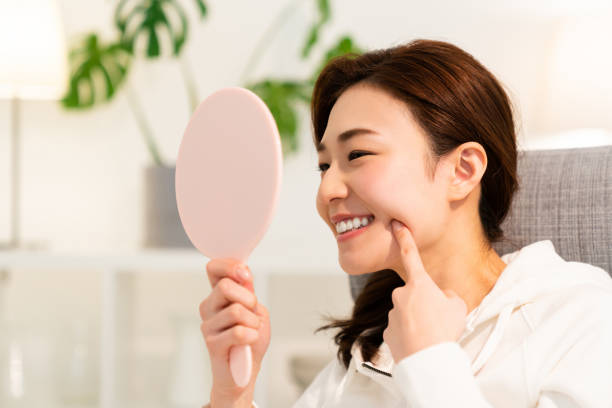 asiatisk kvinna att se en spegel,munvård, - kvinna borstar tänderna bildbanksfoton och bilder