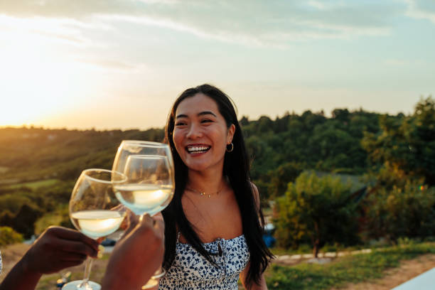 Asian woman toasting with friends at outdoors party stock photo