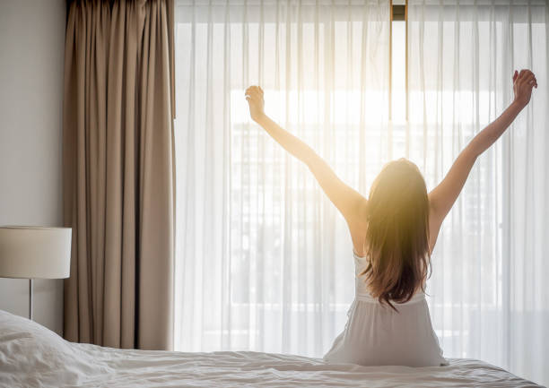 Asian woman wake up in the morning, sitting on white bed and stretching, feeling happy and fresh  waking up stock pictures, royalty-free photos & images