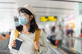 istock Asian woman wearing protective face mask in international airport. 1268389310
