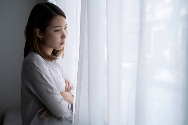 Asian woman with stress, She kept herself alone in her bedroom, Depression. stock photo