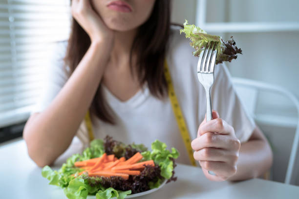 Asian women are not happy, She doesn't want to eat vegetables. stock photo