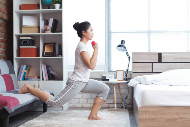 Asian women exercising in bed in the morning, she feels refreshed.She acts as squat. stock photo