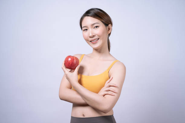 Asian women in yellow sportswear, Isolated on white background, Concept of health care and exercise. stock photo