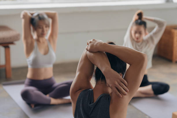 Asian yoga students doing stretching stock photo