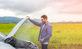 istock Asian young man having trouble car engine overheating and have smoke 1306026140
