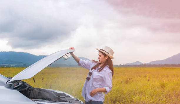 Asian young woman having trouble car engine overheating and have smoke stock photo