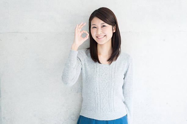 Asian young woman showing OK gesture stock photo